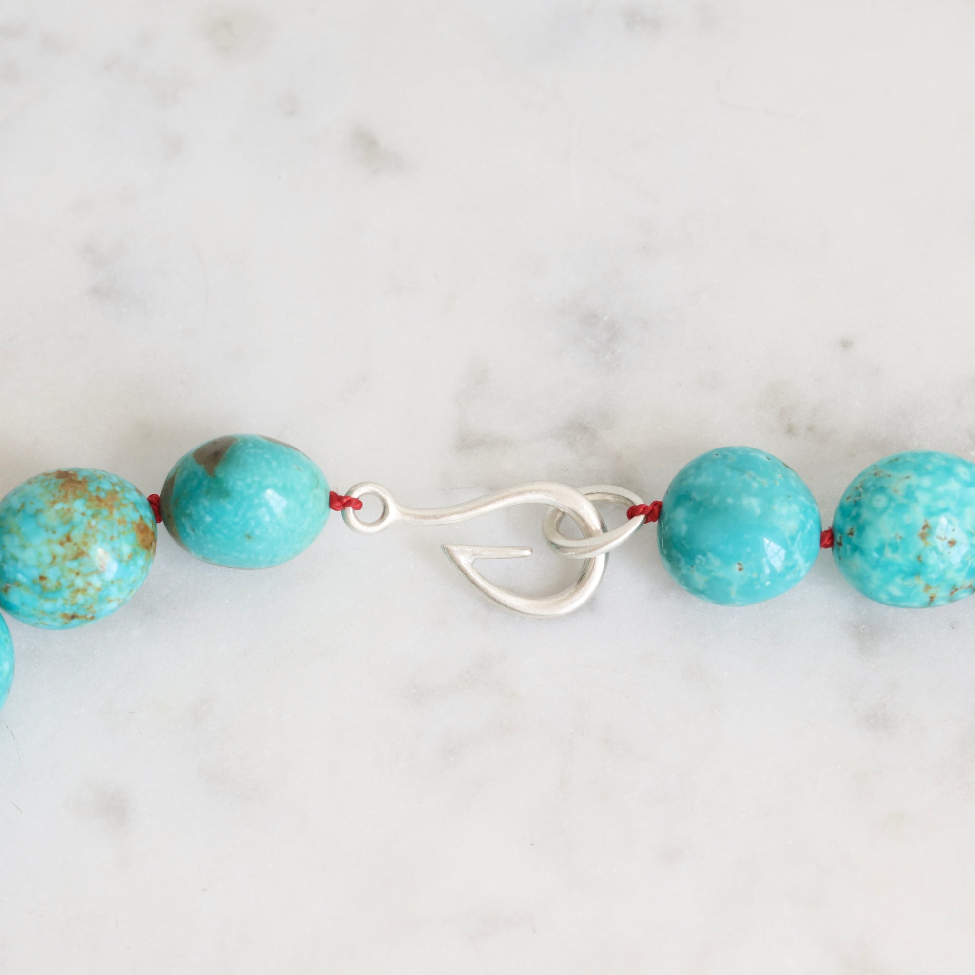Turquoise Strand with silver barnacles and red thread