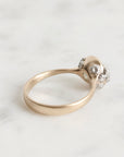 Gold ring with a small diamond on a light gray background