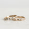 Two gold rings with diamond accents on a light gray background