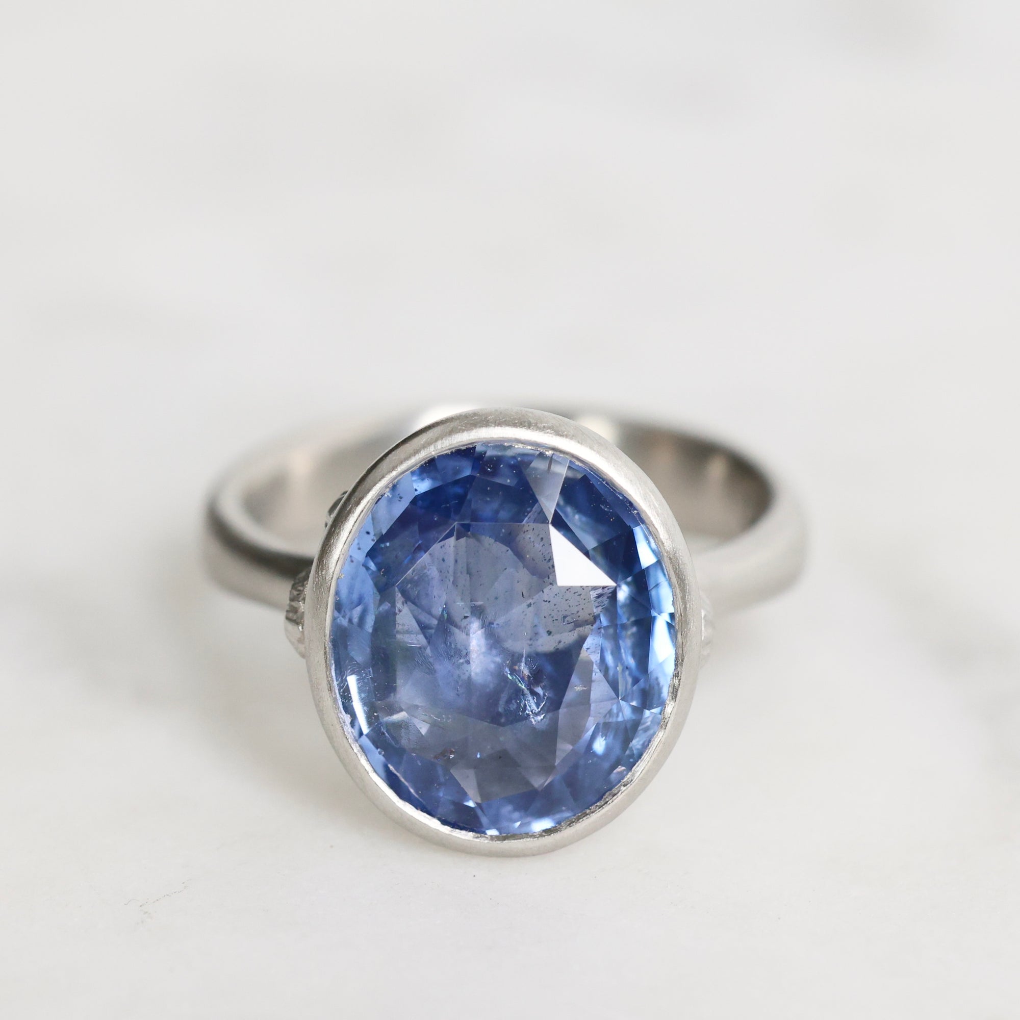 Silver ring with a blue gemstone on a white background