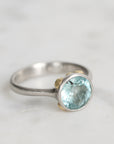 Silver ring with a blue gemstone on a light gray background