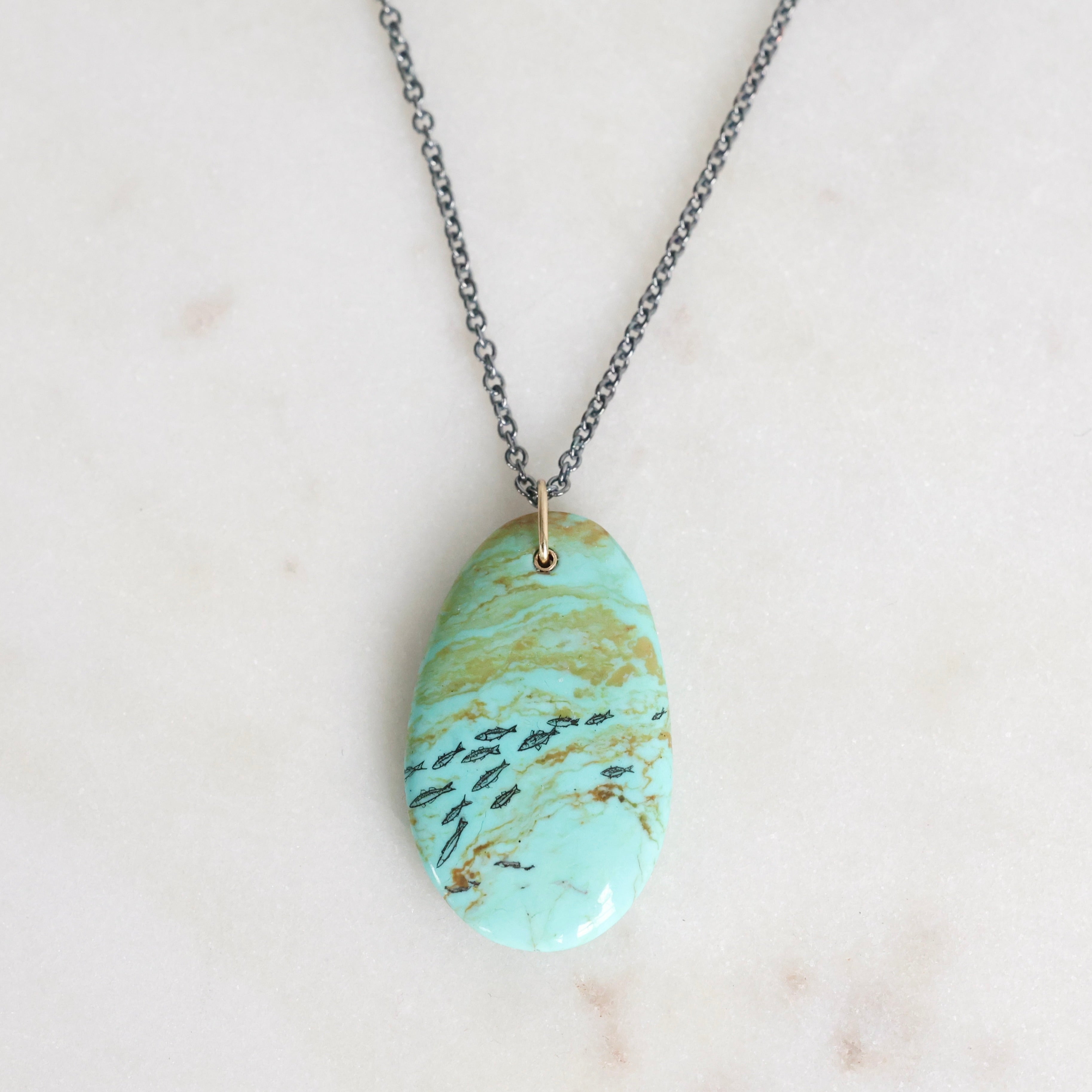 Necklace with a turquoise marbled pendant on a light background