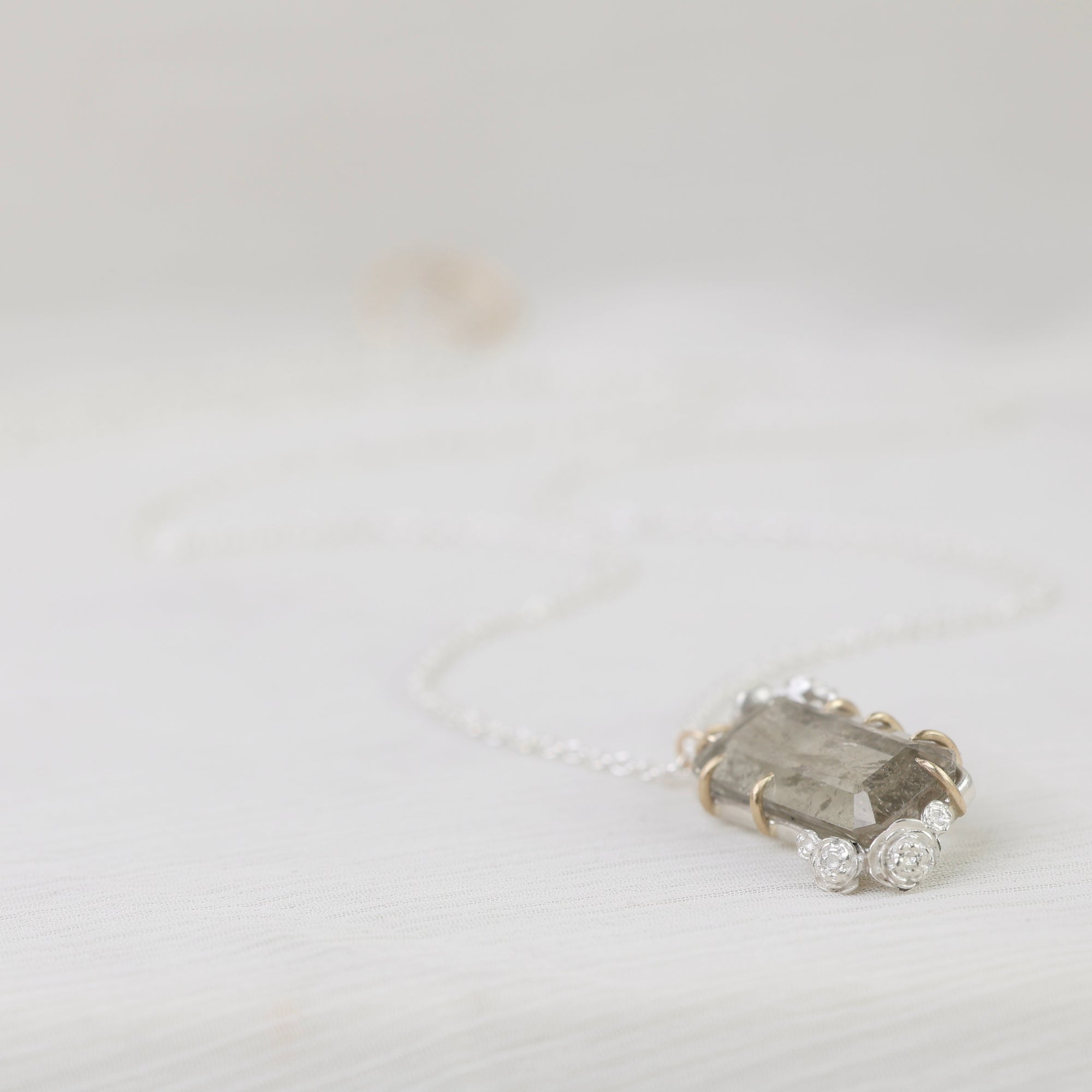 necklace with a grayish stone on a light background