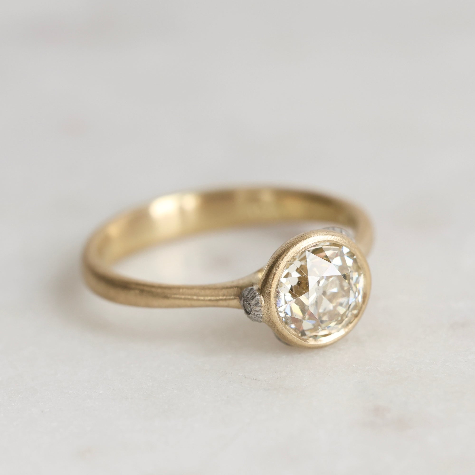 Gold ring with diamond and platinum barnacles on a white background 