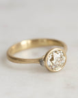 Gold ring with diamond and platinum barnacles on a white background 