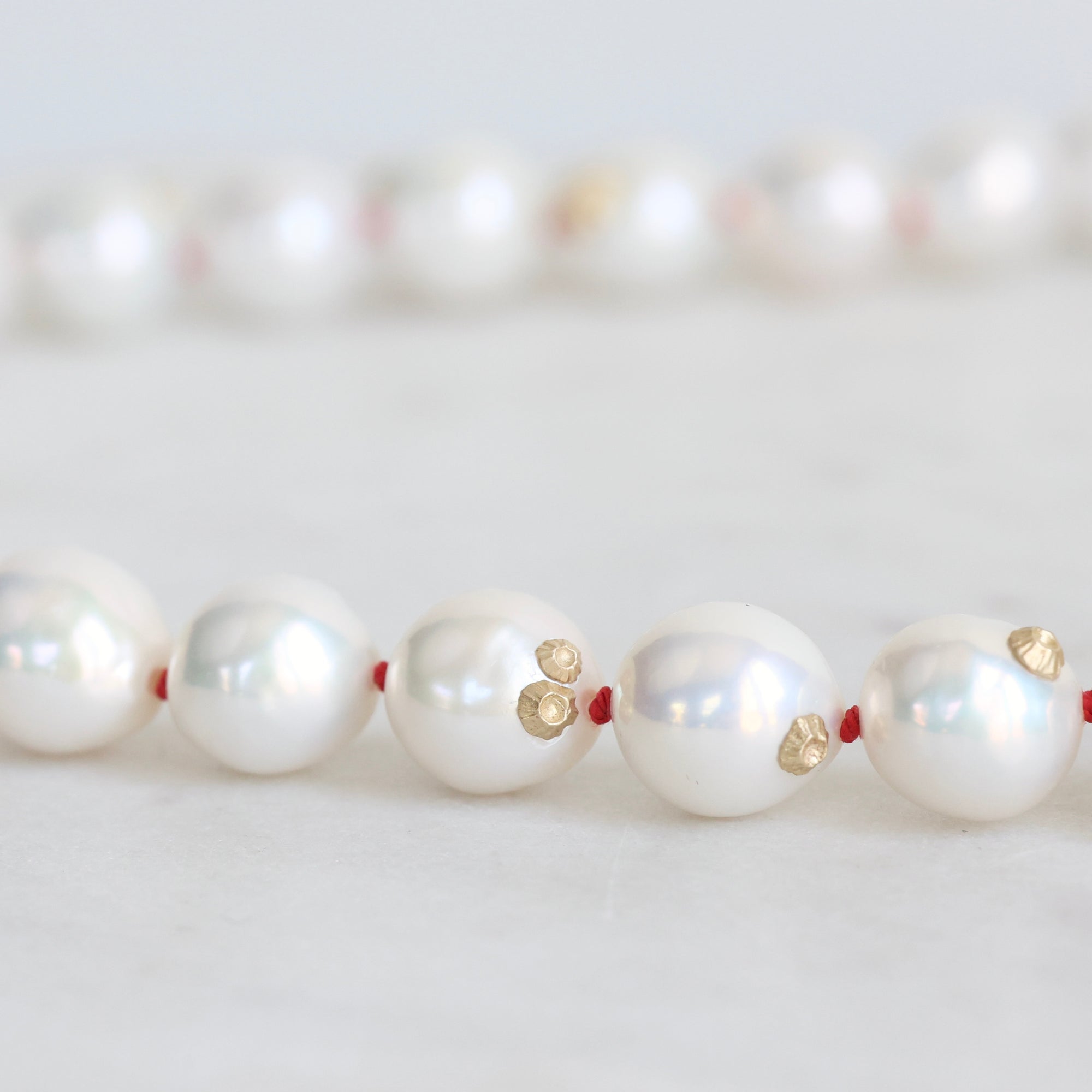 Pearl Strand with gold barnacles and red thread. 