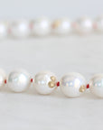 Pearl Strand with gold barnacles and red thread. 