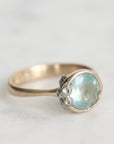 Silver ring with a light blue gemstone on a white background