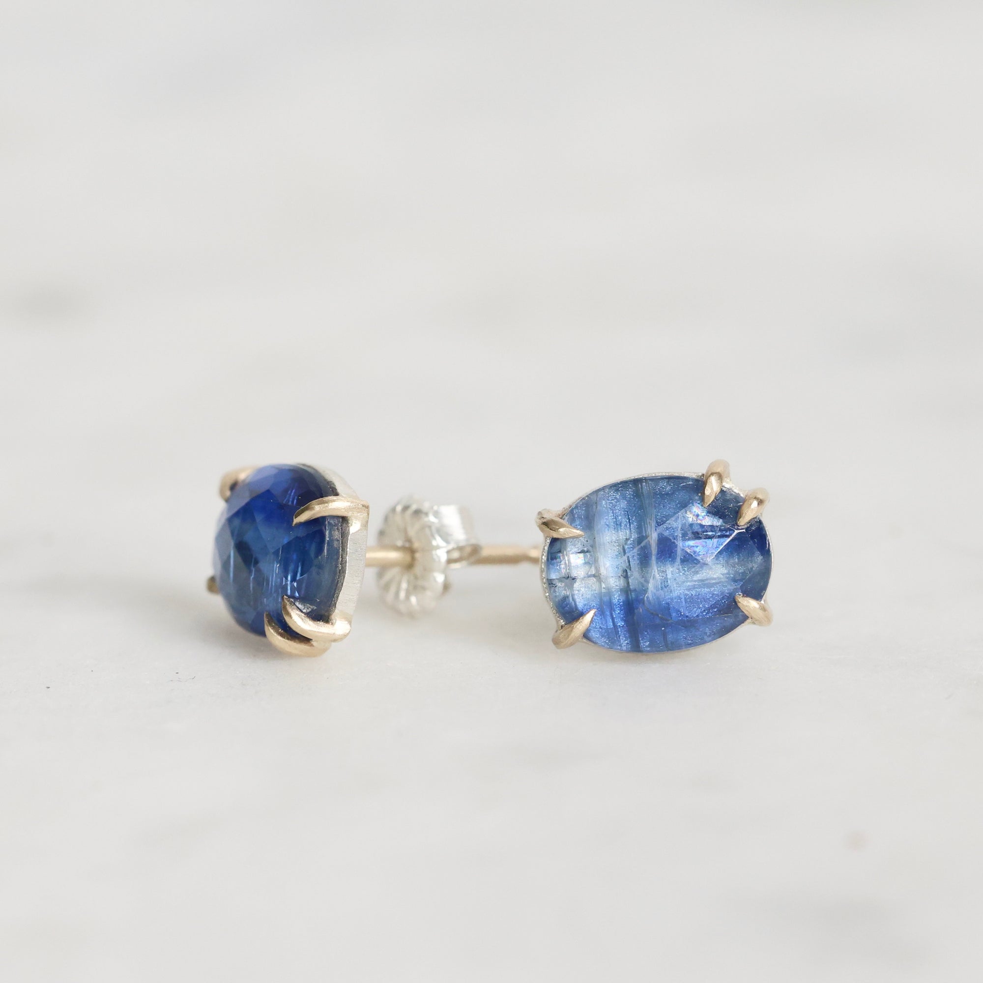 Pair of blue gemstone earrings on a light gray background