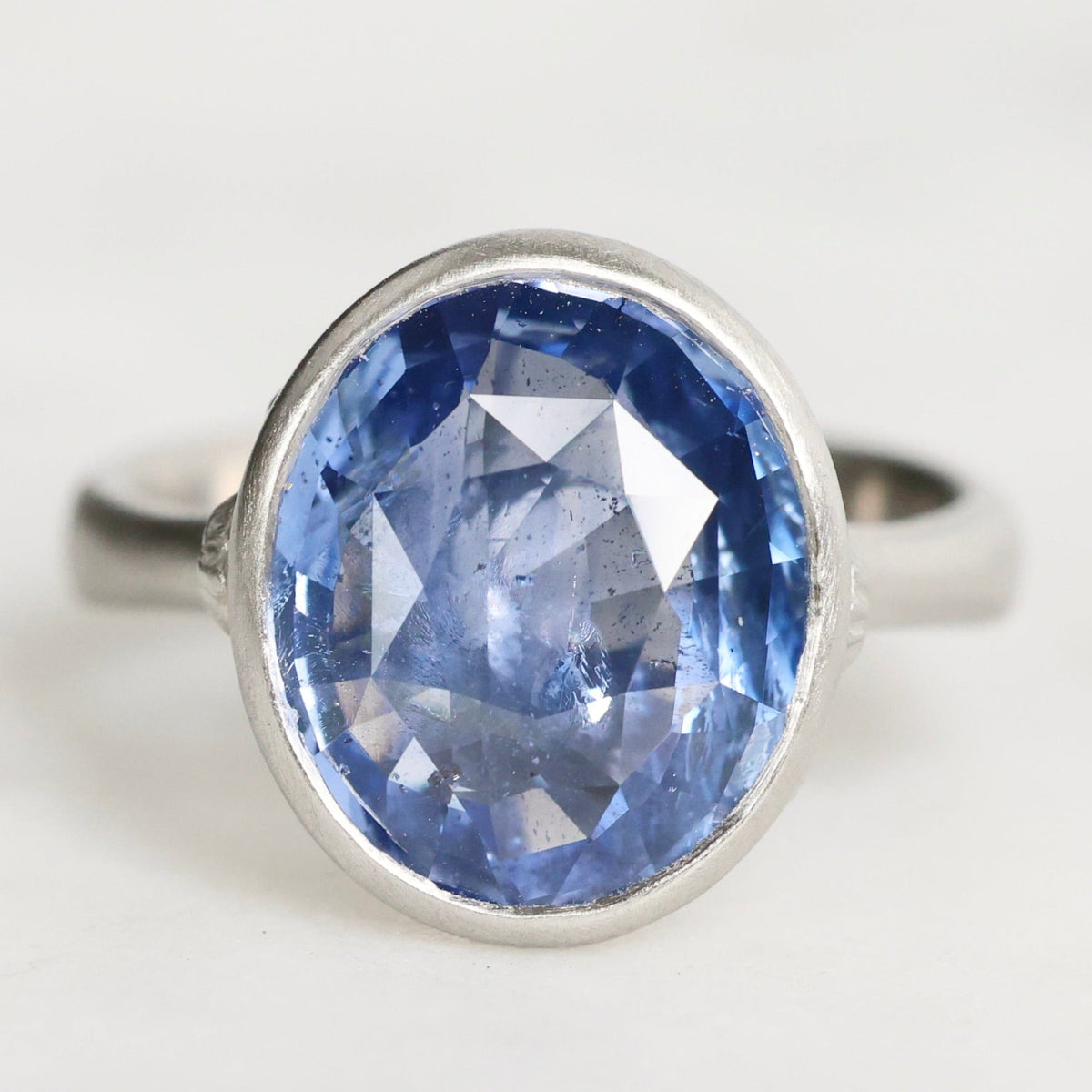 platinum ring with a blue gemstone on a white background