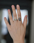 Hand wearing blue gemstone ring. 