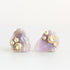 Raw opal studs with barnacle details in gold against a plain background. 