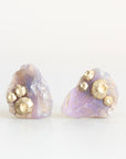 Raw opal studs with barnacle details in gold against a plain background. 