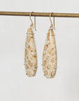 Pair of floral teardrop earrings on a thin rod against a light background