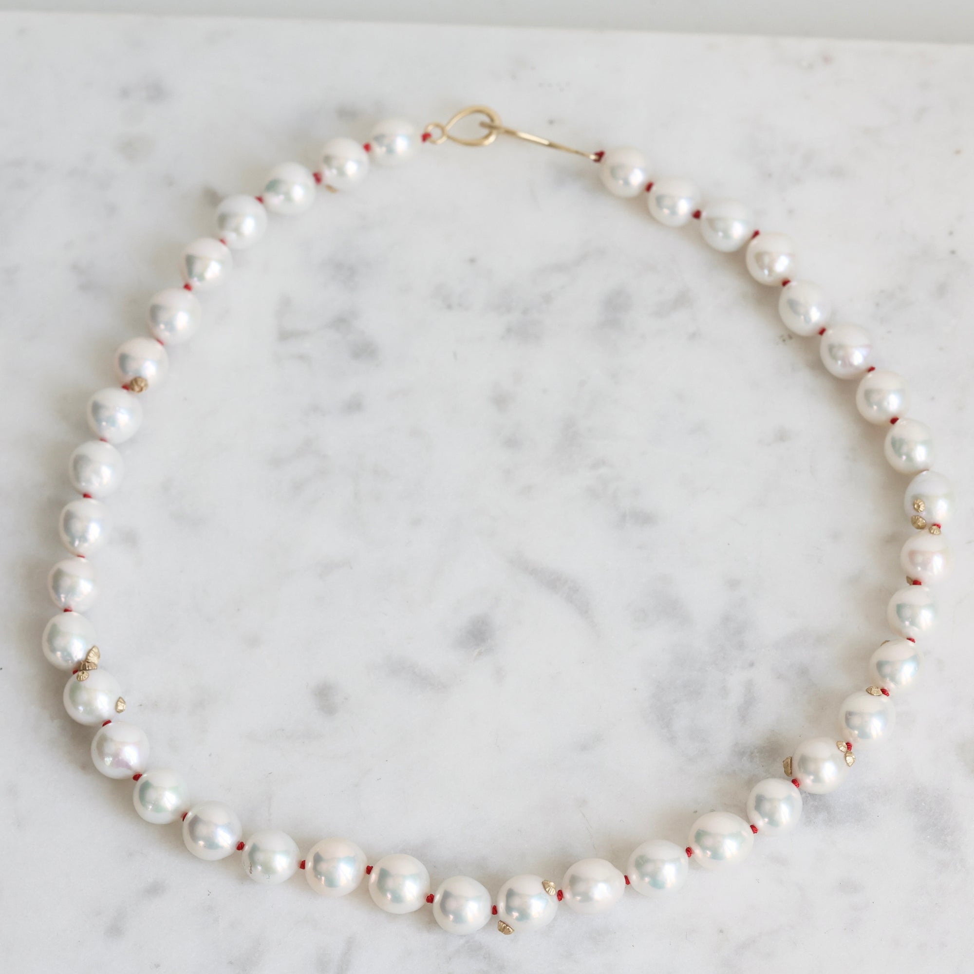 Pearl Strand with gold barnacles and red thread. 