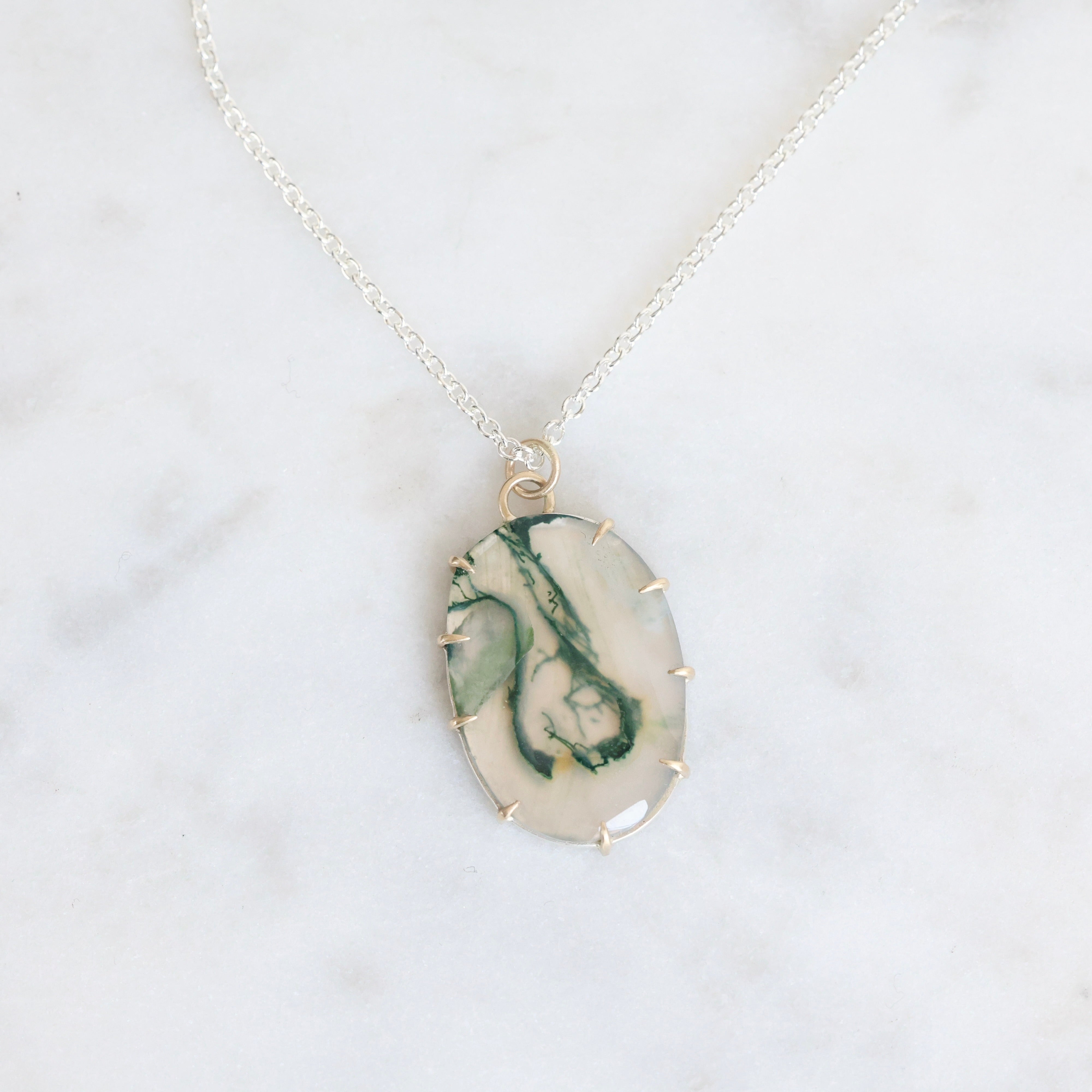 Marble-patterned pendant necklace on a white background