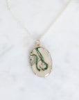 Marble-patterned pendant necklace on a white background