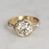 Gold ring with a large diamond on a light gray background
