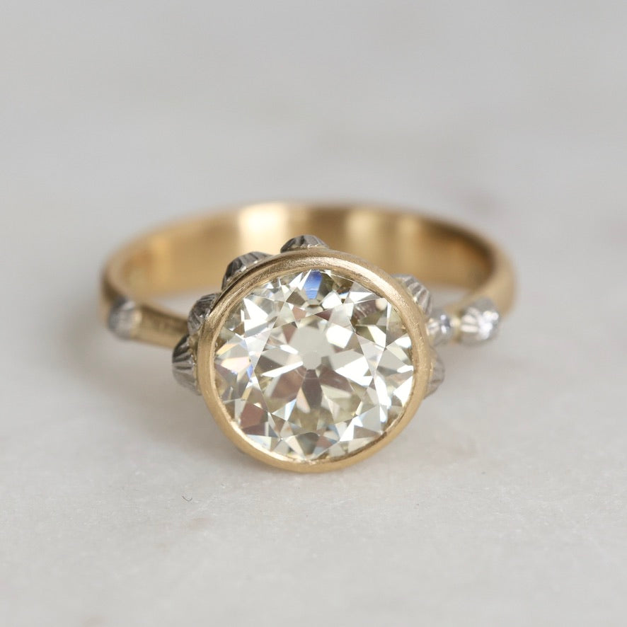 Gold ring with a large diamond on a light gray background