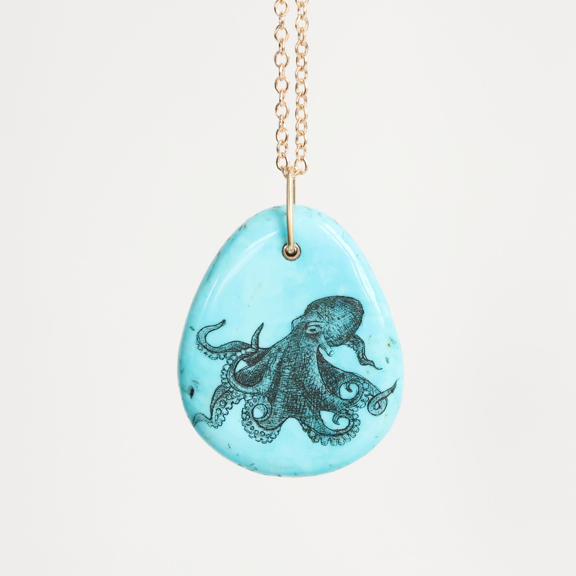 Necklace with a pendant featuring an octopus design on a light blue background