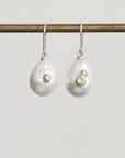 Pair of pearl earrings with silver accents on a white background