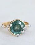 Large green sapphire ring with lots of barnacles. Gold shank. 