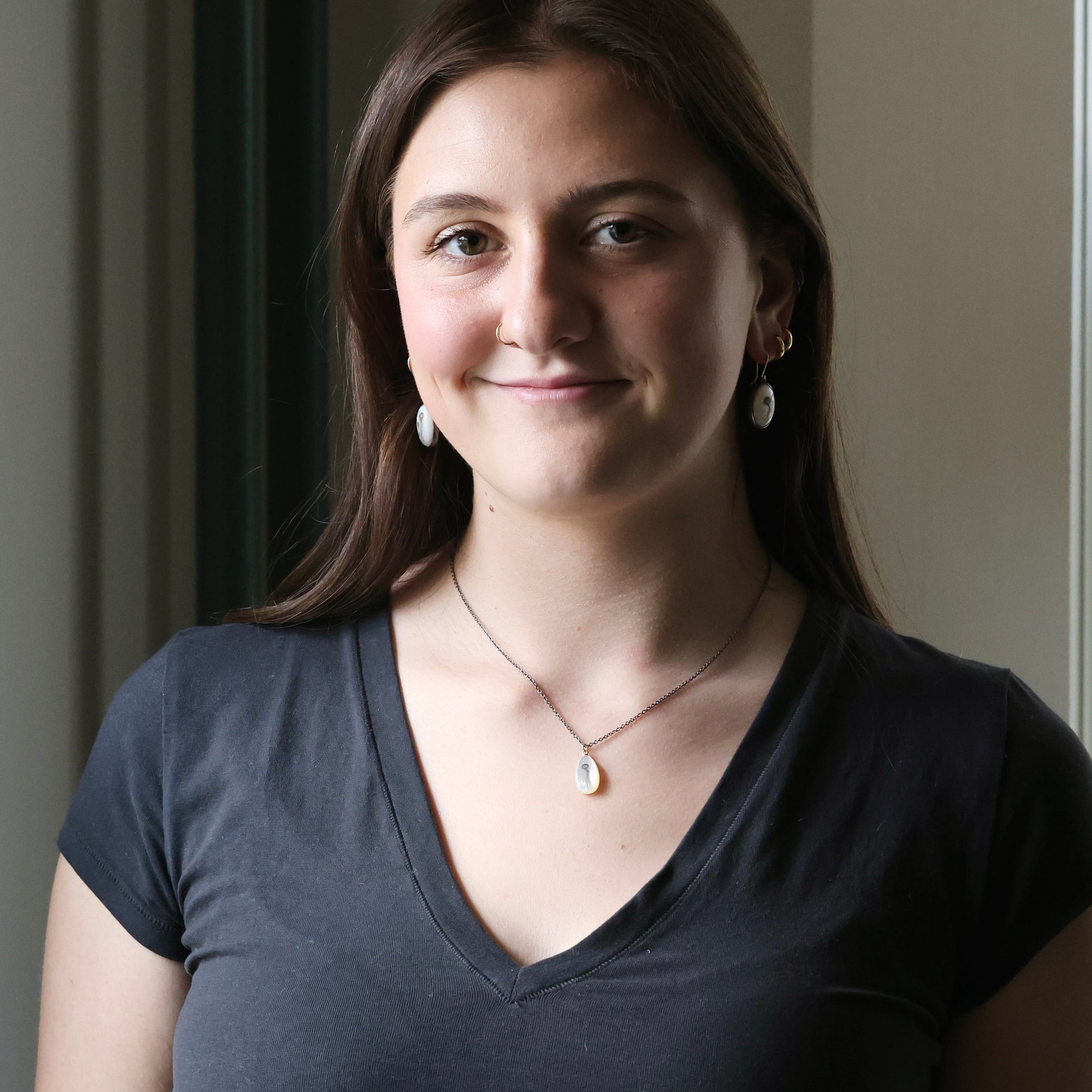 Woman wearing a dark gray shirt with a neutral background