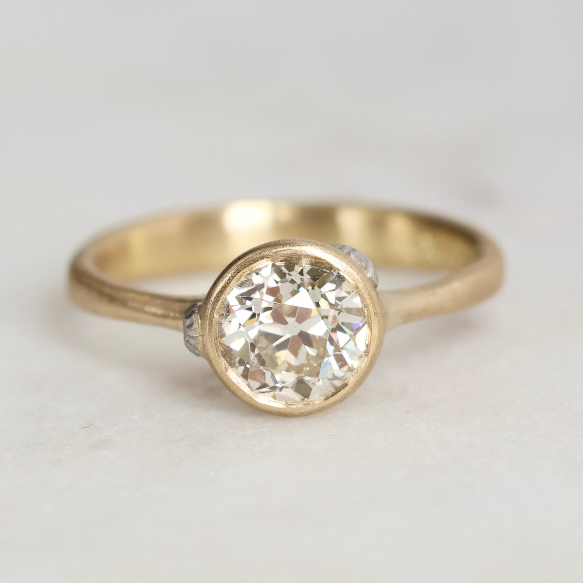 Gold ring with diamond and platinum barnacles on a white background 