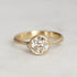 Gold ring with a diamond on a light gray background