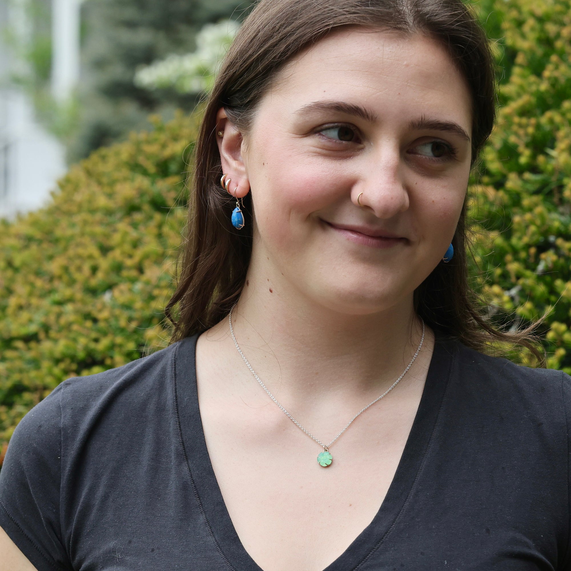 Woman wearing necklace with green pendant 