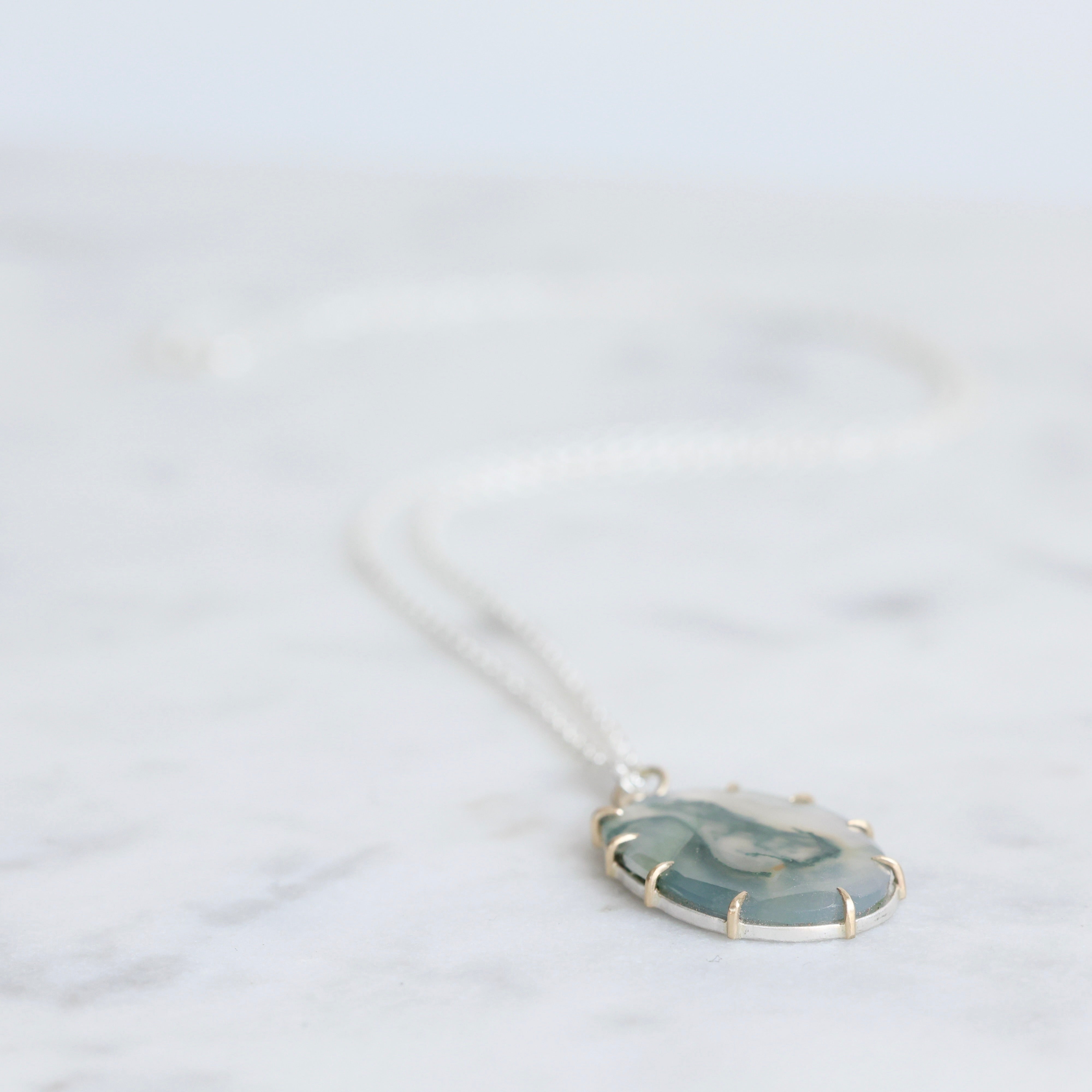 Necklace with a pendant on a light gray background