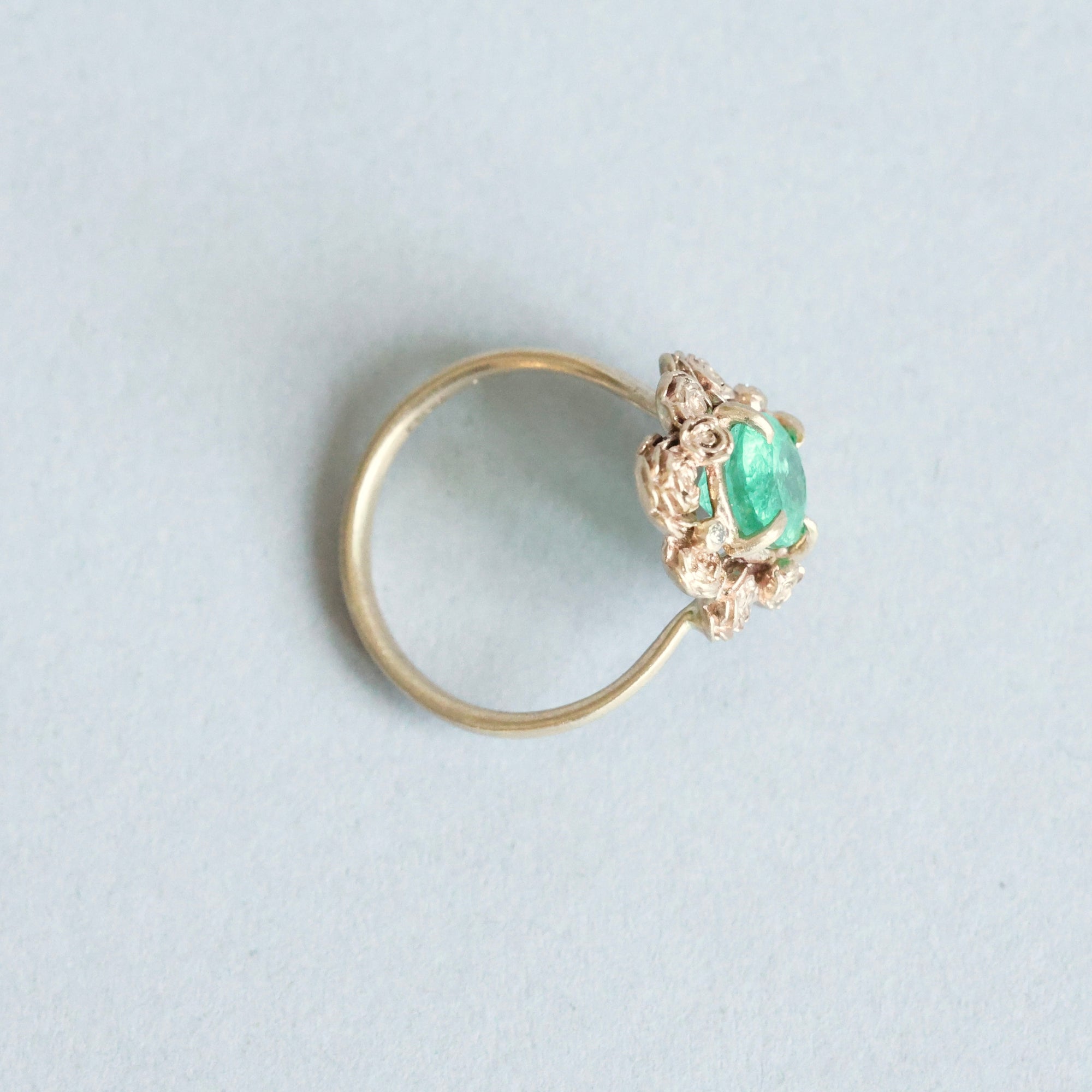 Green stone surrounded by golden rose setting 