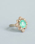 Green stone surrounded by golden rose setting 