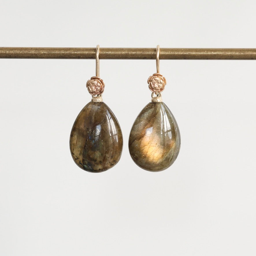 Teardrop-shaped earrings with gold accents on a white background