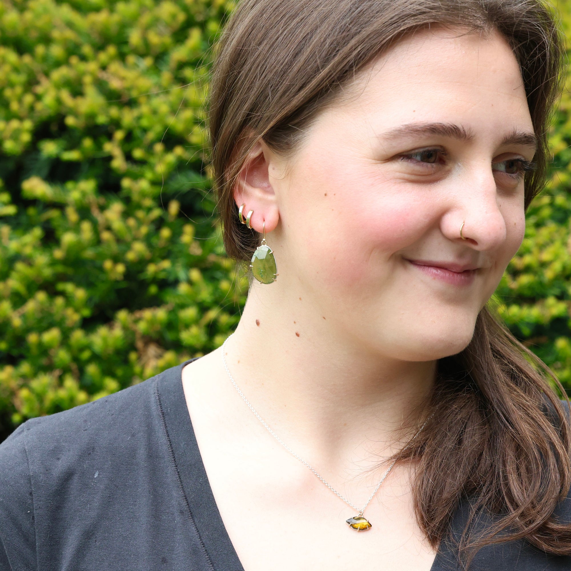 woman wearing green earrings outside