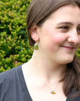 woman wearing green earrings outside