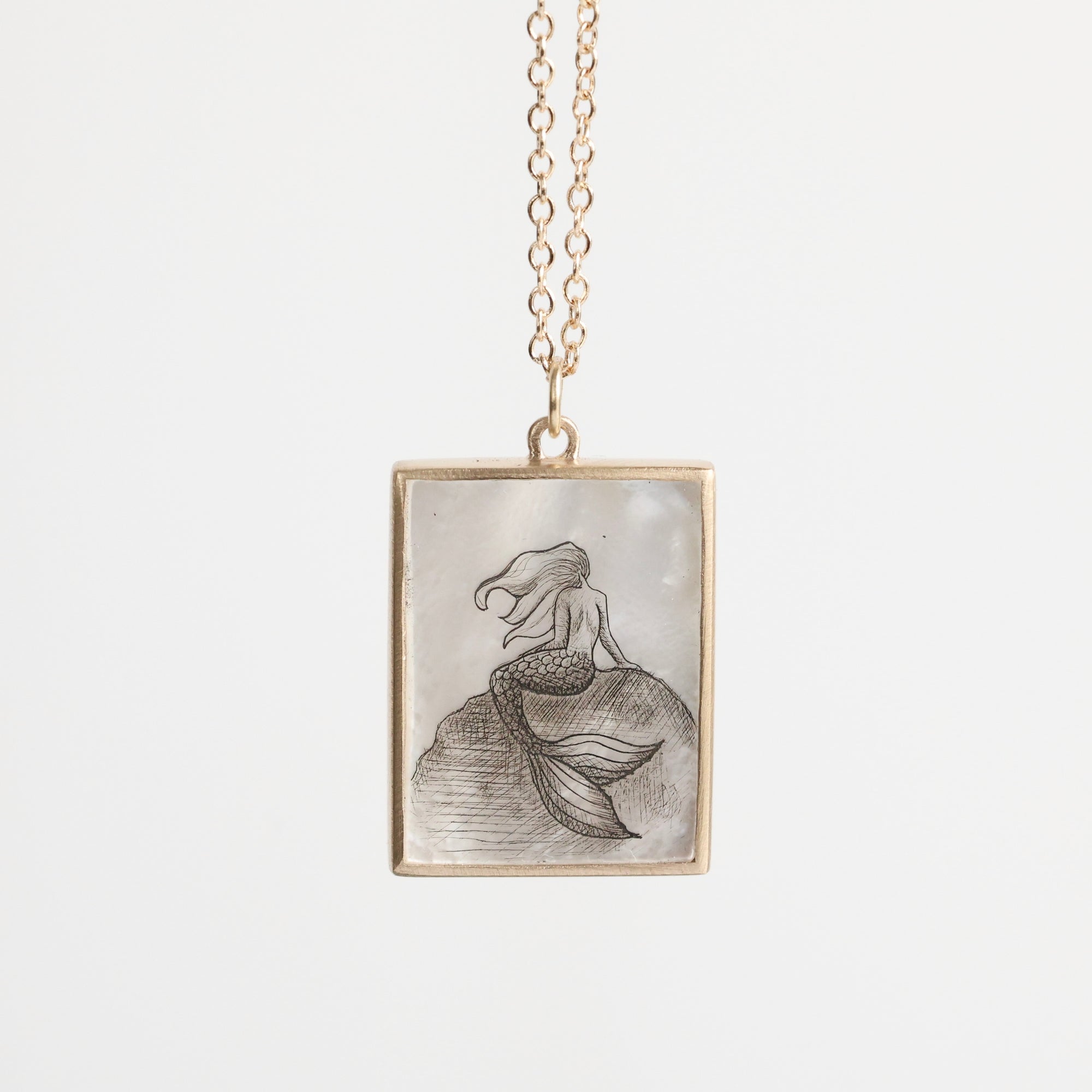 Mermaid pendant necklace on a white background