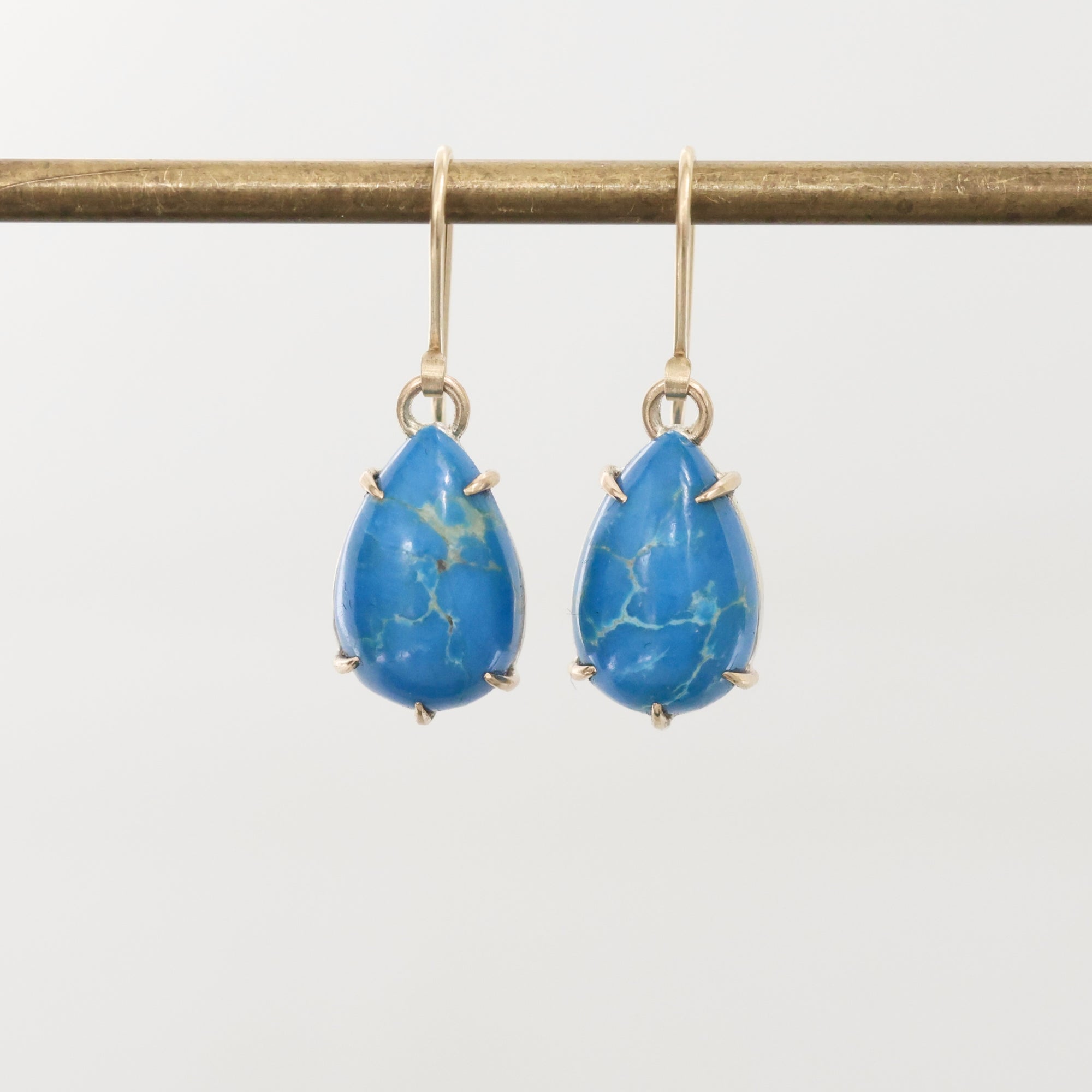Pair of blue teardrop earrings on a white background