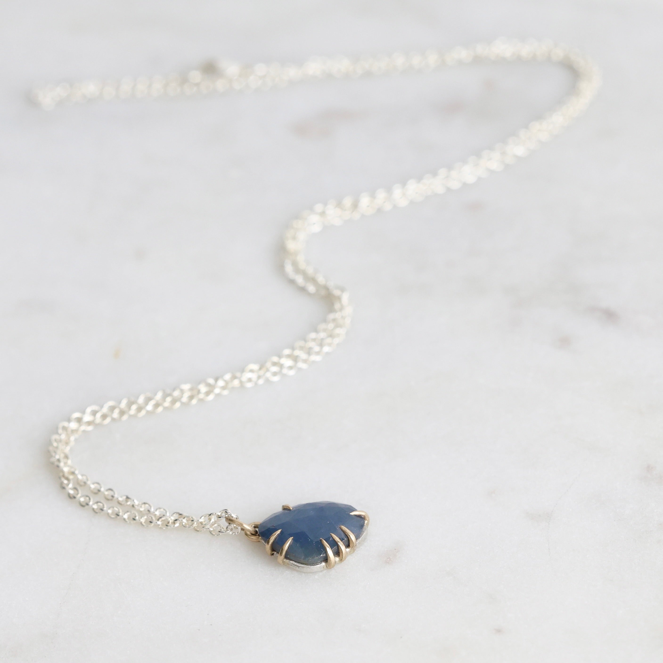 Necklace with a blue pendant on a light gray background