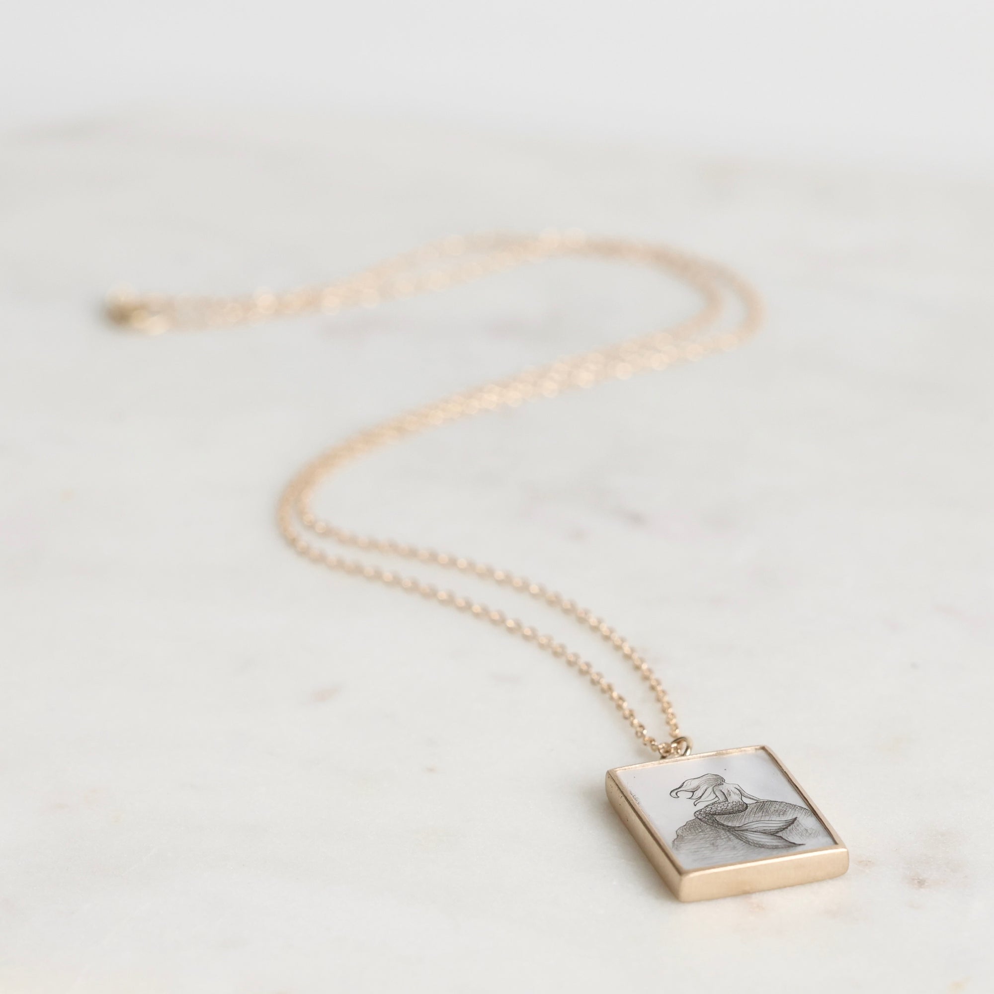Necklace with a square pendant on a light background