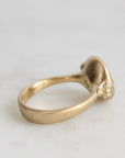 Gold ring with a small decorative element on a light gray background