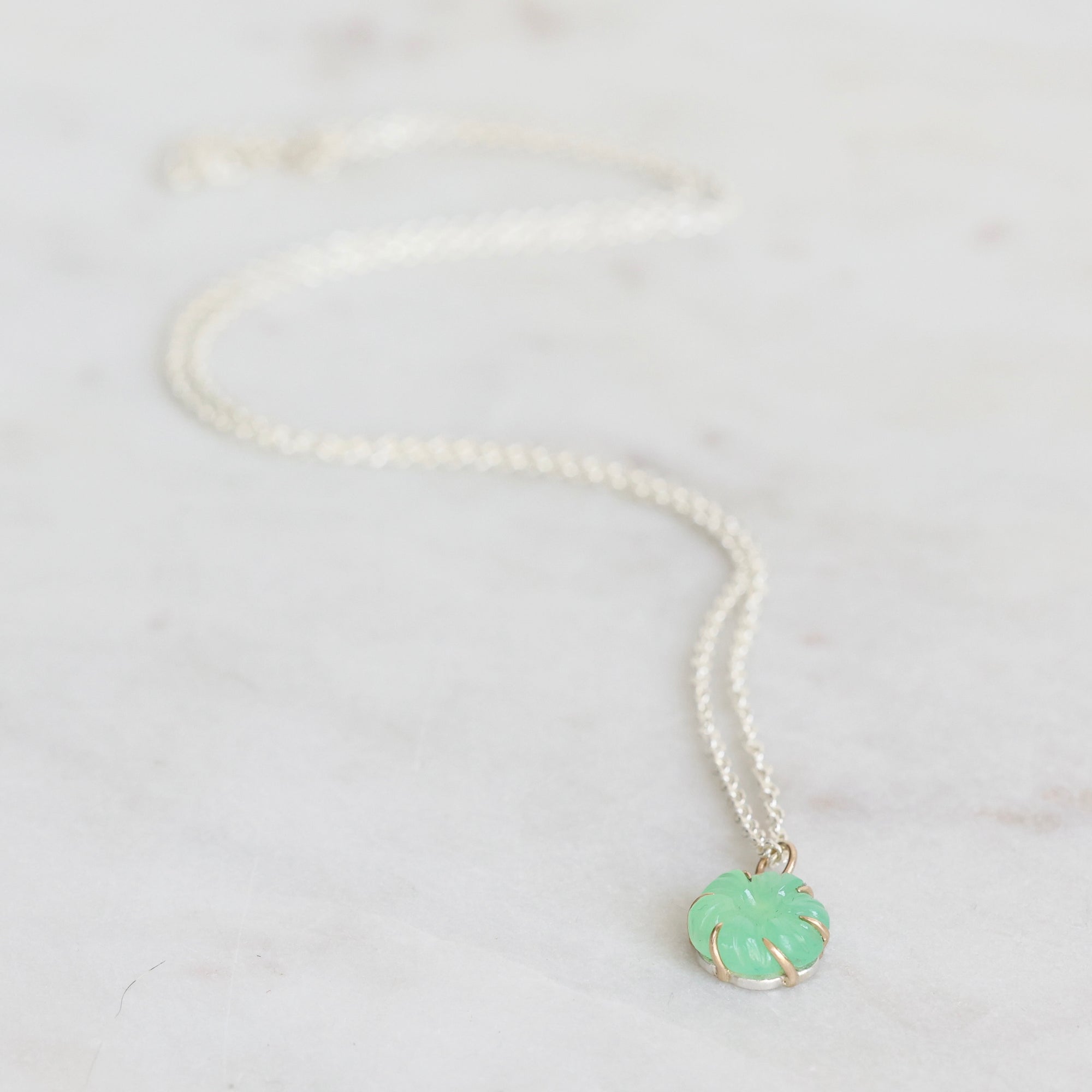 Necklace with a green pendant on a white background