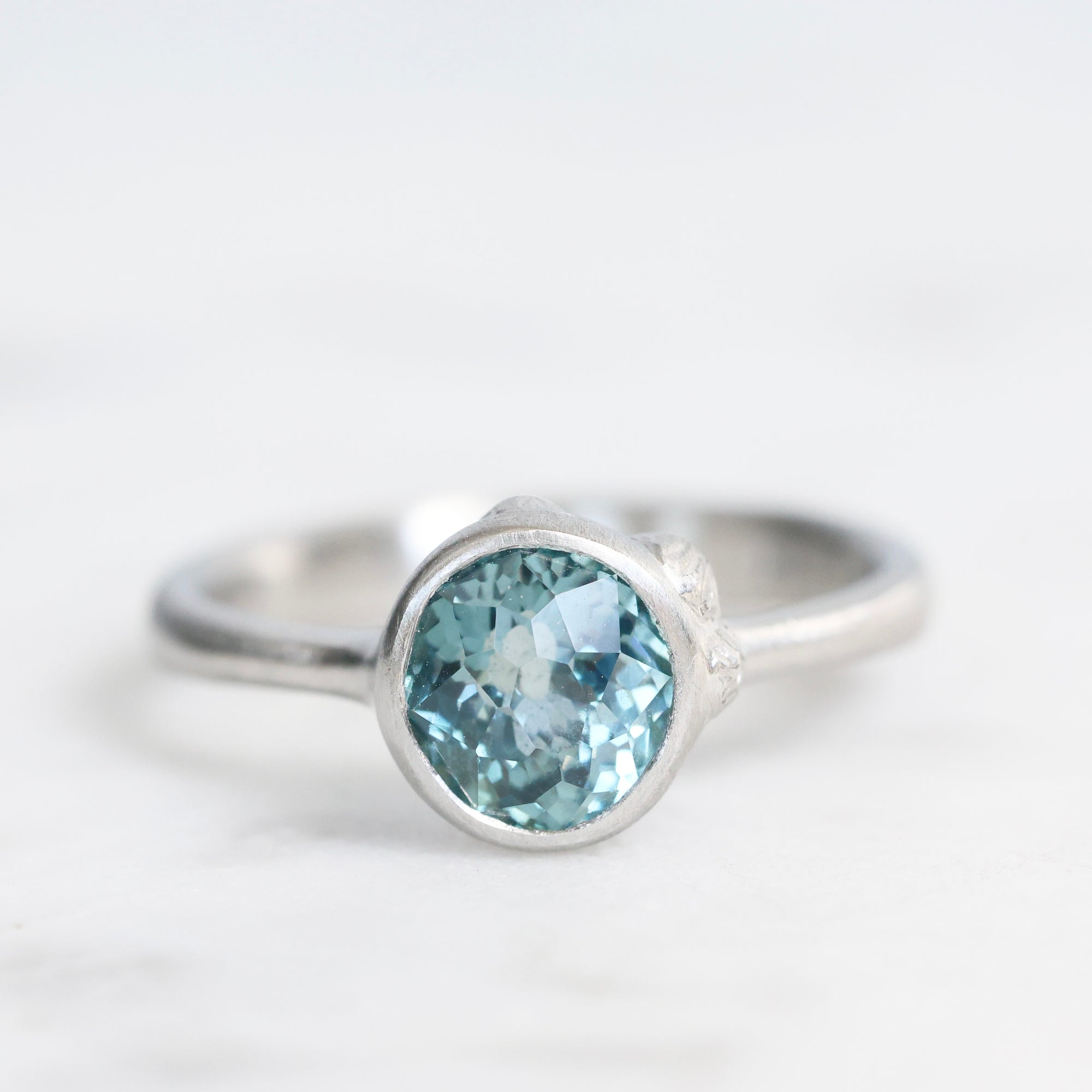 Silver ring with a blue gemstone on a white background