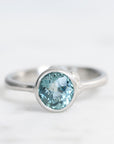 Silver ring with a blue gemstone on a white background