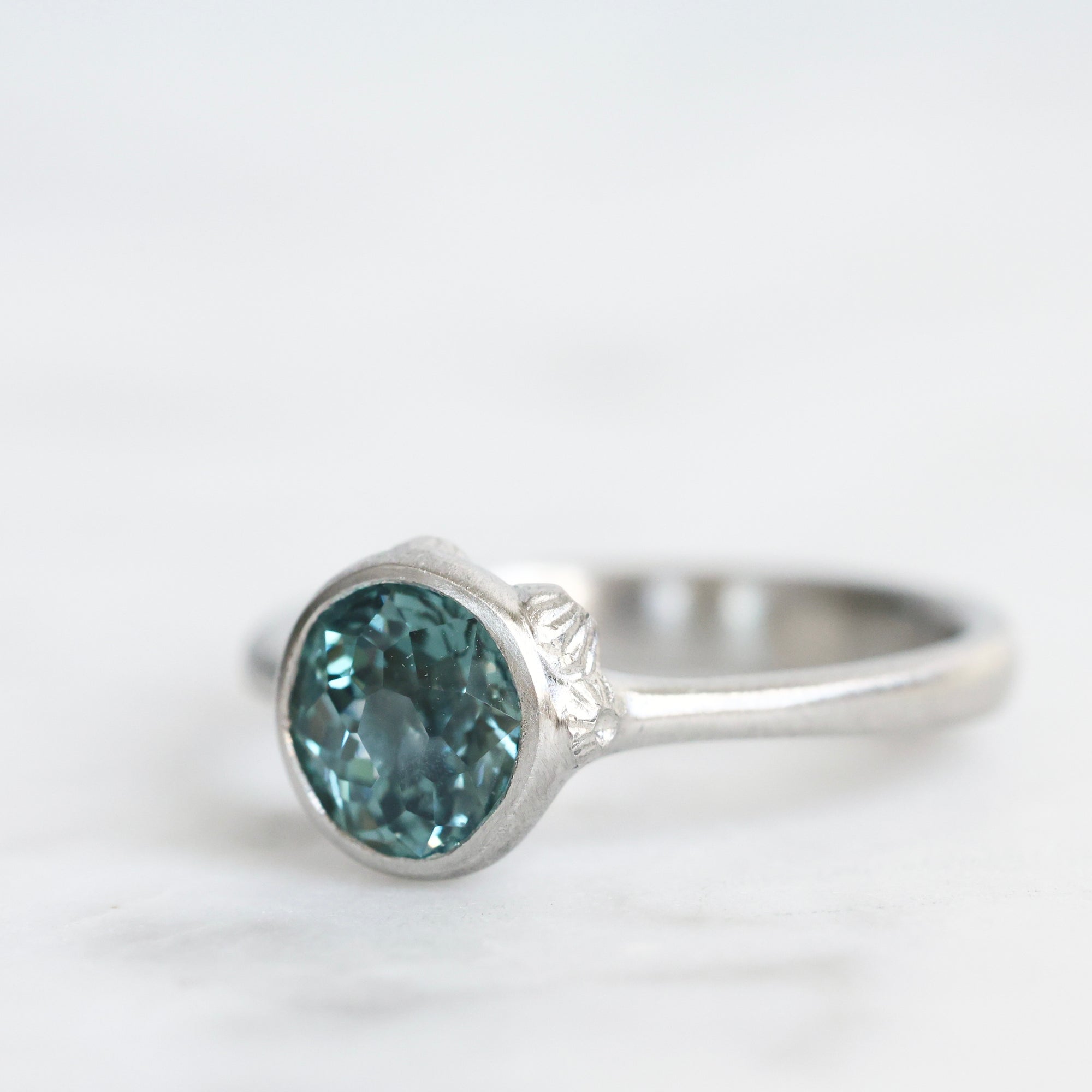 Silver ring with a blue gemstone on a white background