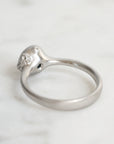 Silver ring with a small diamond on a light gray background