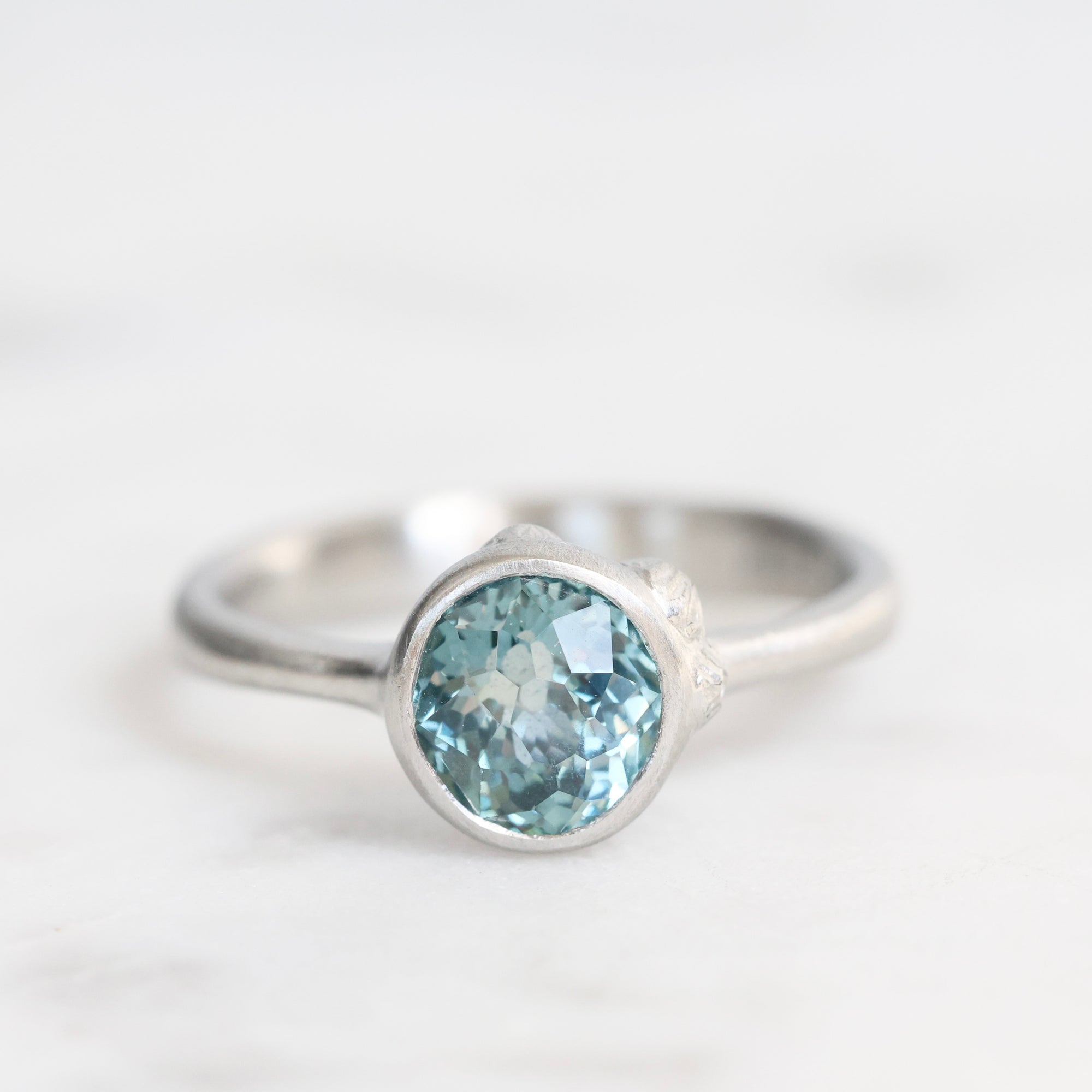 Silver ring with a blue gemstone on a white background