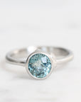 Silver ring with a blue gemstone on a white background