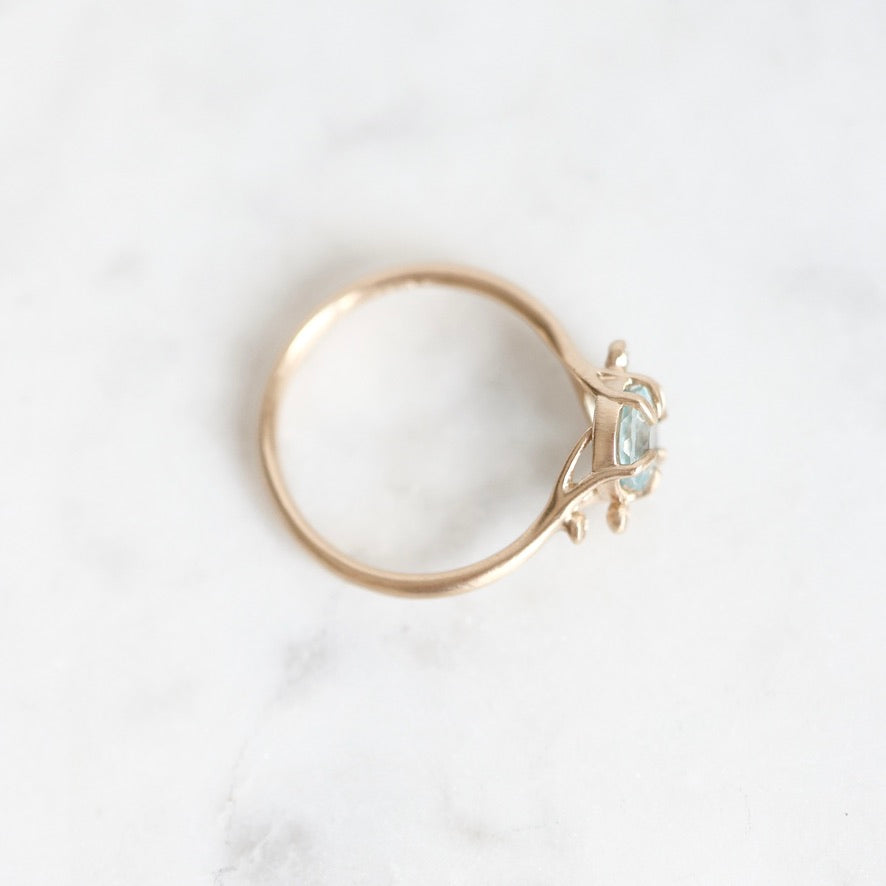 Top view of gold ring with branchy prongs and berries. 