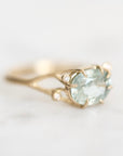 gemstone ring set east west in branchy prongs. Little diamond accents surround the center stone